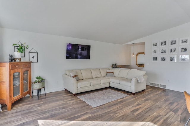 living area featuring lofted ceiling, wood finished floors, visible vents, and baseboards