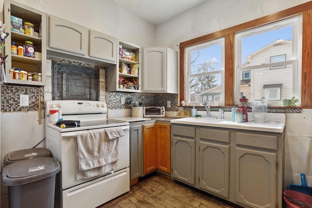 kitchen with white electric range, open shelves, a sink, wood finished floors, and light countertops