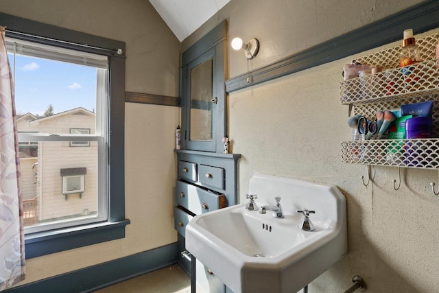 bathroom featuring a sink and lofted ceiling