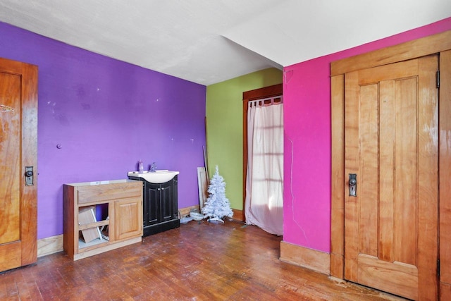 unfurnished bedroom featuring a sink and hardwood / wood-style flooring