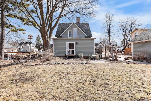 rear view of property featuring a patio, a residential view, and a chimney