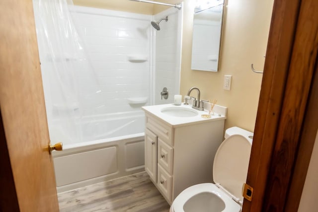 bathroom with vanity,  shower combination, toilet, and wood finished floors