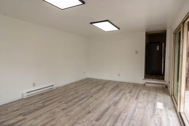 empty room with baseboard heating and light wood-type flooring