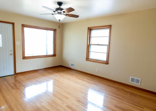 foyer entrance with visible vents, plenty of natural light, and light wood-type flooring