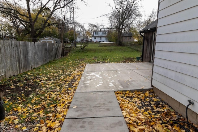 view of yard with a patio area, a fenced backyard, and an outbuilding