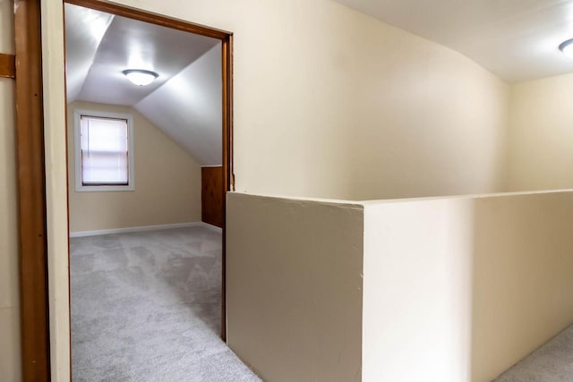 hallway with vaulted ceiling and carpet floors