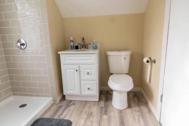 full bath with toilet, wood finished floors, a shower stall, baseboards, and vanity