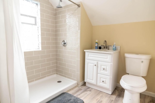 bathroom featuring vaulted ceiling, a shower stall, toilet, and wood finished floors