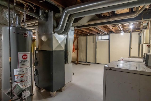 below grade area featuring gas water heater, heating unit, and washer and clothes dryer