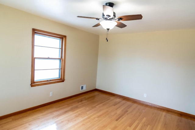 empty room featuring visible vents, light wood-style flooring, baseboards, and ceiling fan