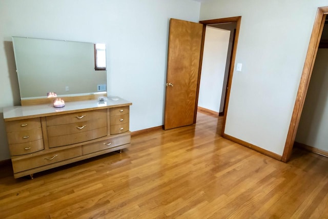 unfurnished bedroom featuring visible vents, light wood-type flooring, and baseboards