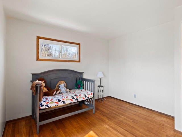 bedroom featuring baseboards and wood finished floors