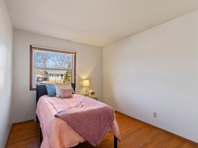 bedroom featuring baseboards and wood finished floors