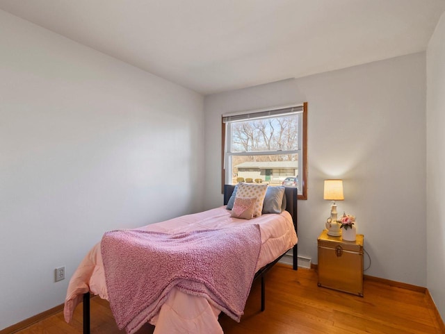 bedroom featuring baseboards and wood finished floors