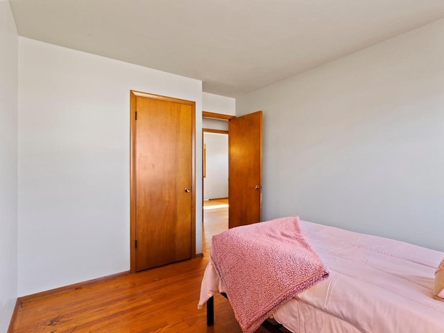 bedroom featuring wood finished floors and baseboards