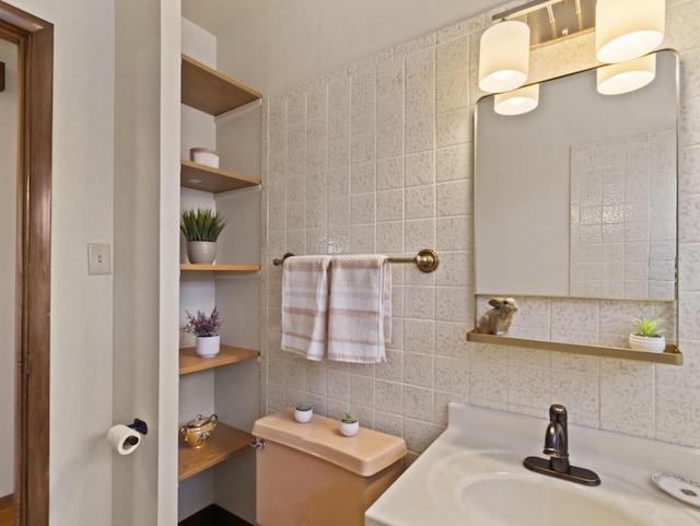 bathroom featuring backsplash, toilet, tile walls, and a sink