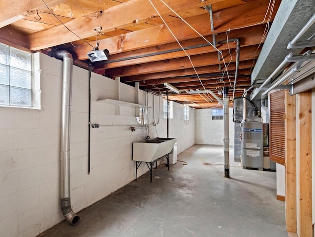 basement featuring a sink and heating unit