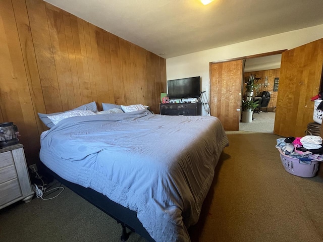 bedroom with wooden walls and carpet flooring