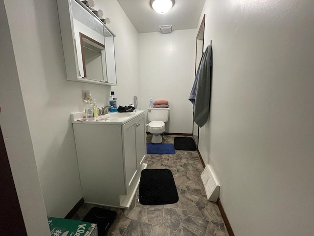 bathroom featuring visible vents, baseboards, toilet, and vanity