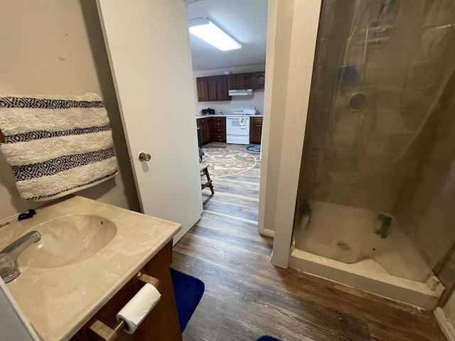 bathroom featuring wood finished floors, a stall shower, and vanity