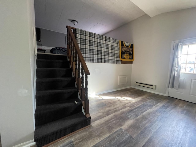 staircase featuring baseboards, a baseboard heating unit, lofted ceiling, and wood finished floors