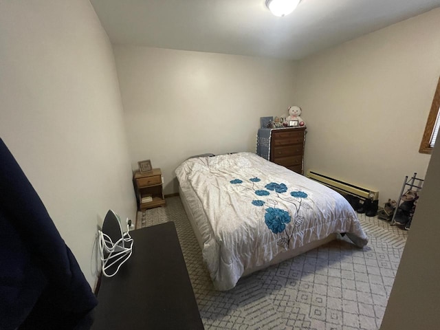 bedroom with a baseboard heating unit and carpet