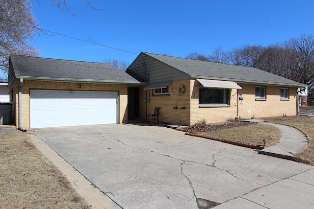 ranch-style home featuring brick siding, driveway, a shingled roof, and a garage