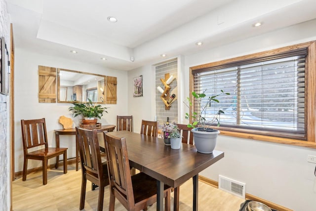 dining area with a healthy amount of sunlight, visible vents, light wood finished floors, and baseboards