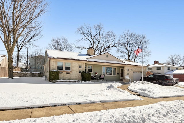 view of front of home with brick siding, an attached garage, a chimney, and fence