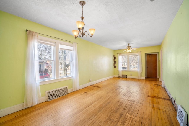 unfurnished room featuring visible vents, a textured ceiling, baseboards, and hardwood / wood-style floors