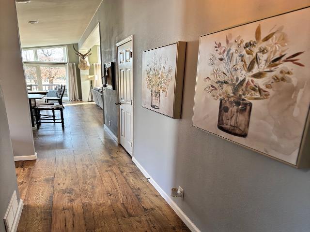 hall featuring baseboards and wood-type flooring