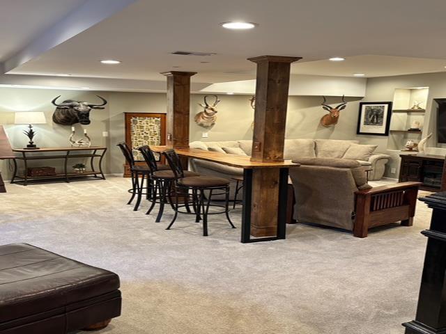 living room featuring carpet flooring, recessed lighting, visible vents, and decorative columns