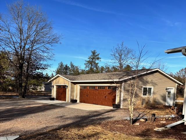 garage with gravel driveway