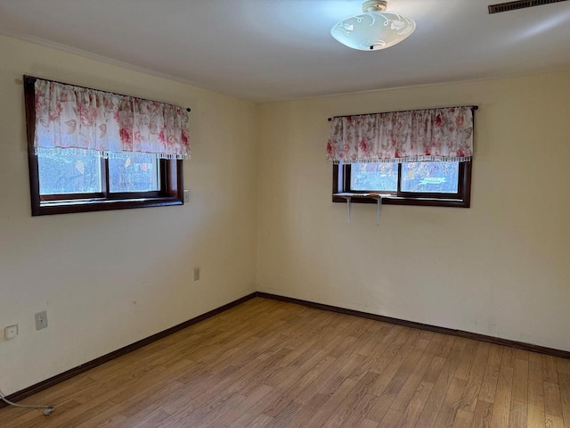 empty room featuring light wood-style flooring and baseboards