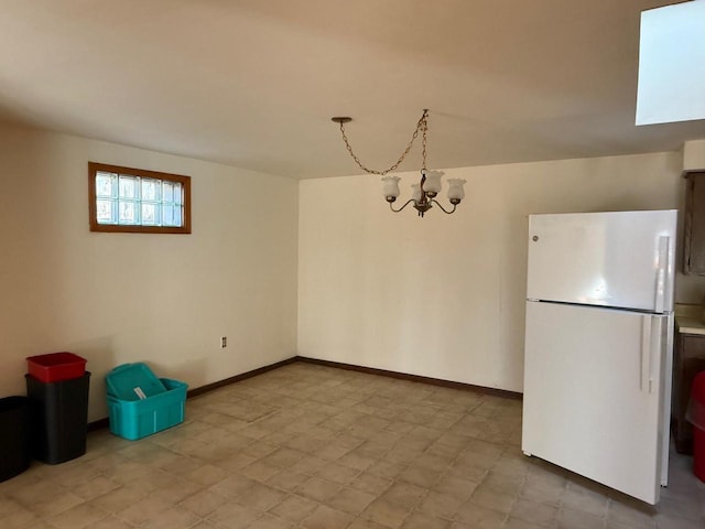 unfurnished dining area with baseboards, a notable chandelier, and light floors