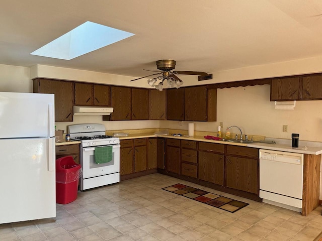 kitchen with visible vents, under cabinet range hood, light countertops, a skylight, and white appliances