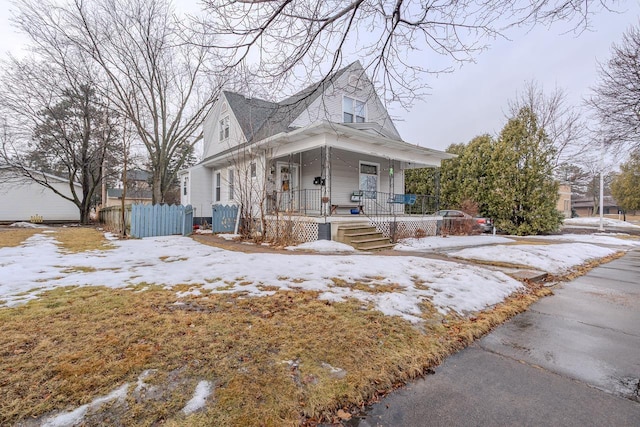 view of front of home featuring a porch and fence