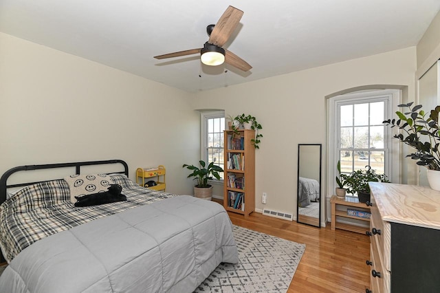 bedroom featuring multiple windows, a ceiling fan, visible vents, and light wood-type flooring