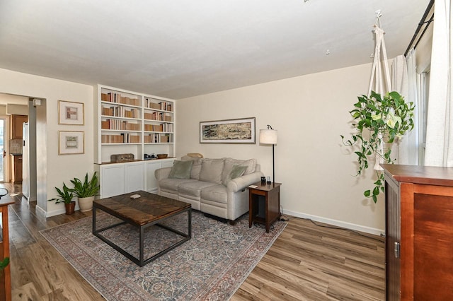 living room with plenty of natural light, baseboards, and wood finished floors