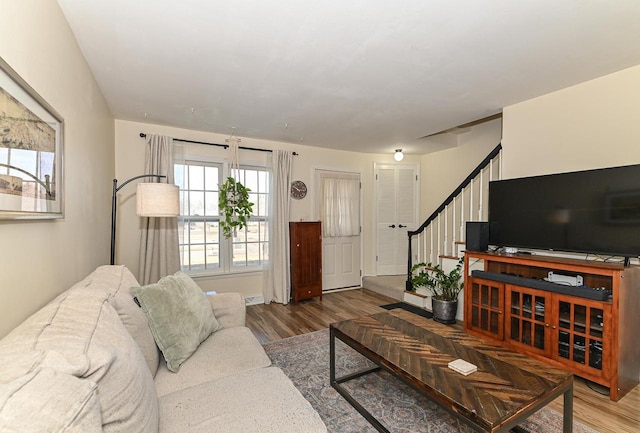 living area featuring stairway and wood finished floors