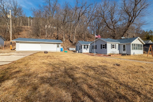 view of front of house featuring a front lawn, an outbuilding, and a garage