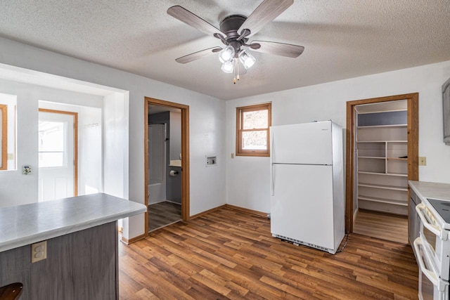 kitchen featuring ceiling fan, white appliances, a textured ceiling, and dark wood finished floors