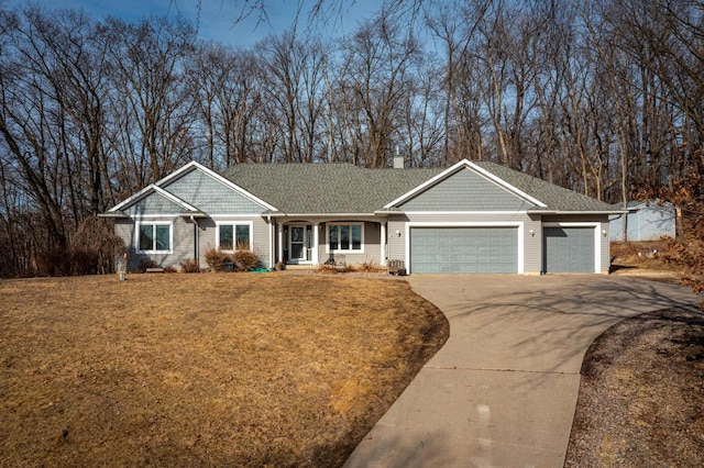 view of front of home featuring a front lawn, roof with shingles, concrete driveway, an attached garage, and a chimney