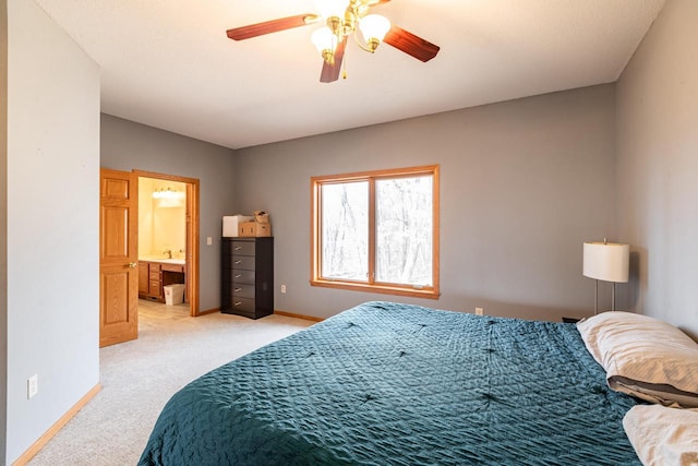 bedroom with connected bathroom, baseboards, light colored carpet, and ceiling fan