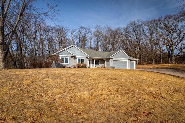 view of front facade featuring a garage, driveway, a chimney, and a front lawn