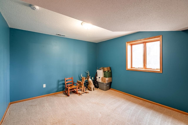 recreation room with baseboards, visible vents, carpet floors, and a textured ceiling