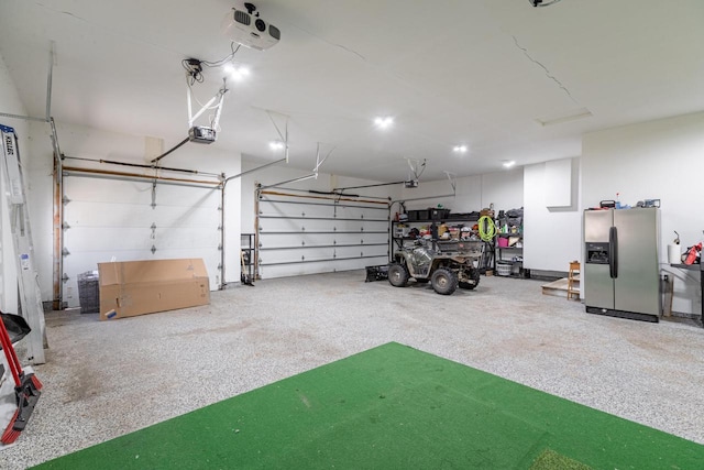 garage with stainless steel fridge and a garage door opener