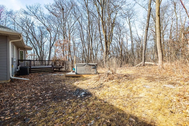 view of yard featuring central AC, a hot tub, and a wooden deck