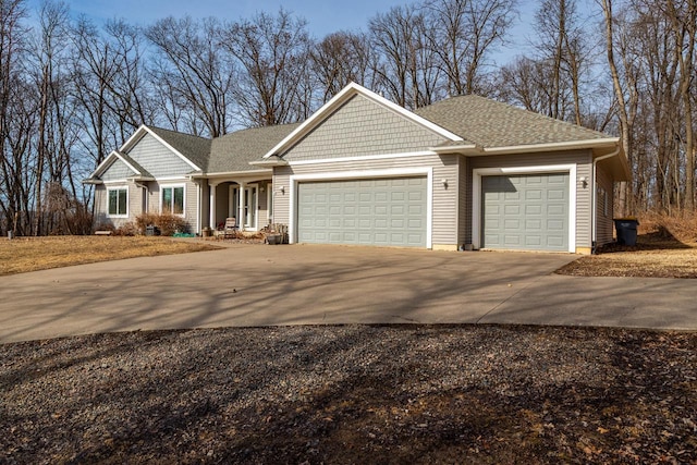 craftsman house with driveway, a garage, and roof with shingles