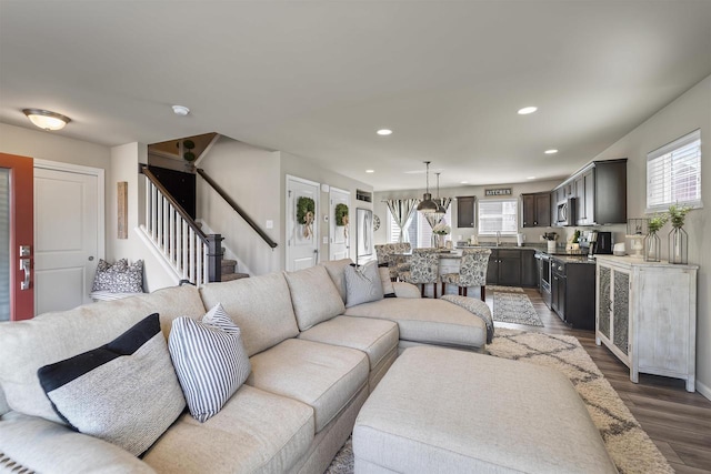 living room with recessed lighting, stairway, and wood finished floors